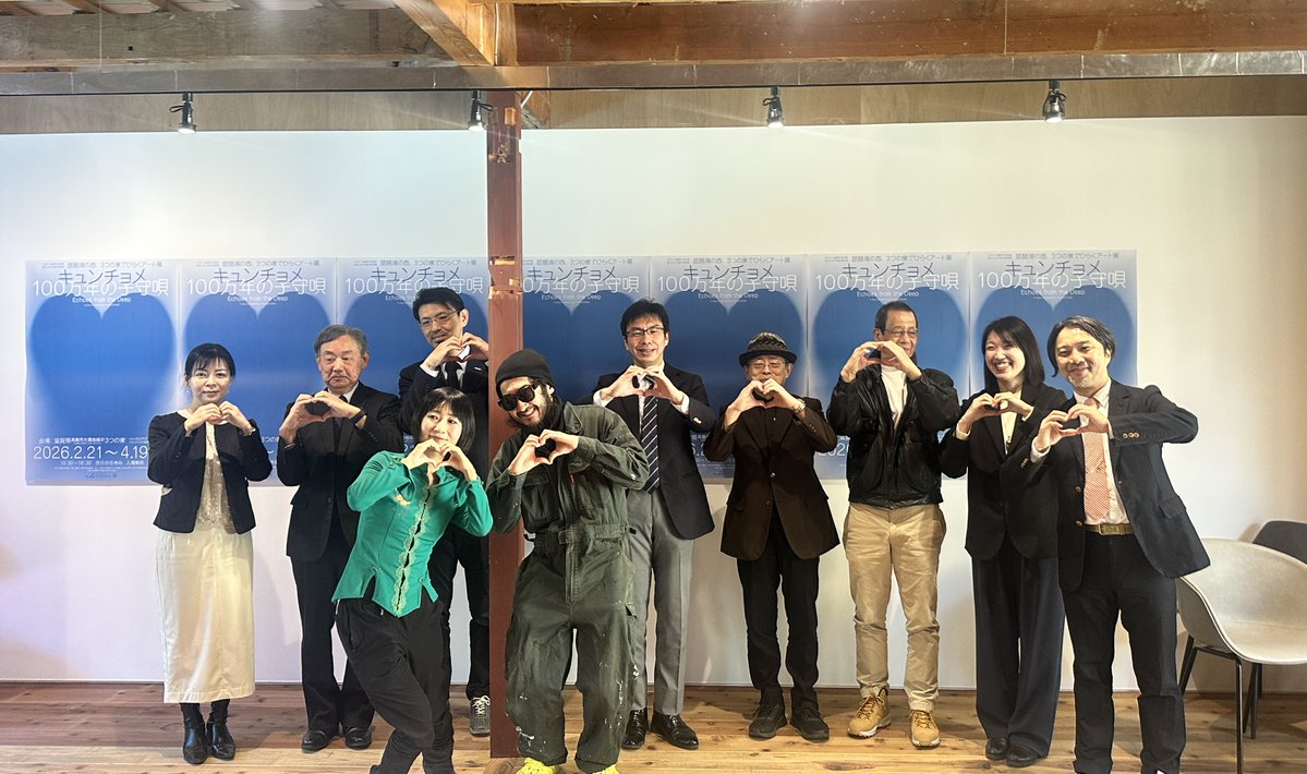 会場外観と街並みを背景にした展示告知