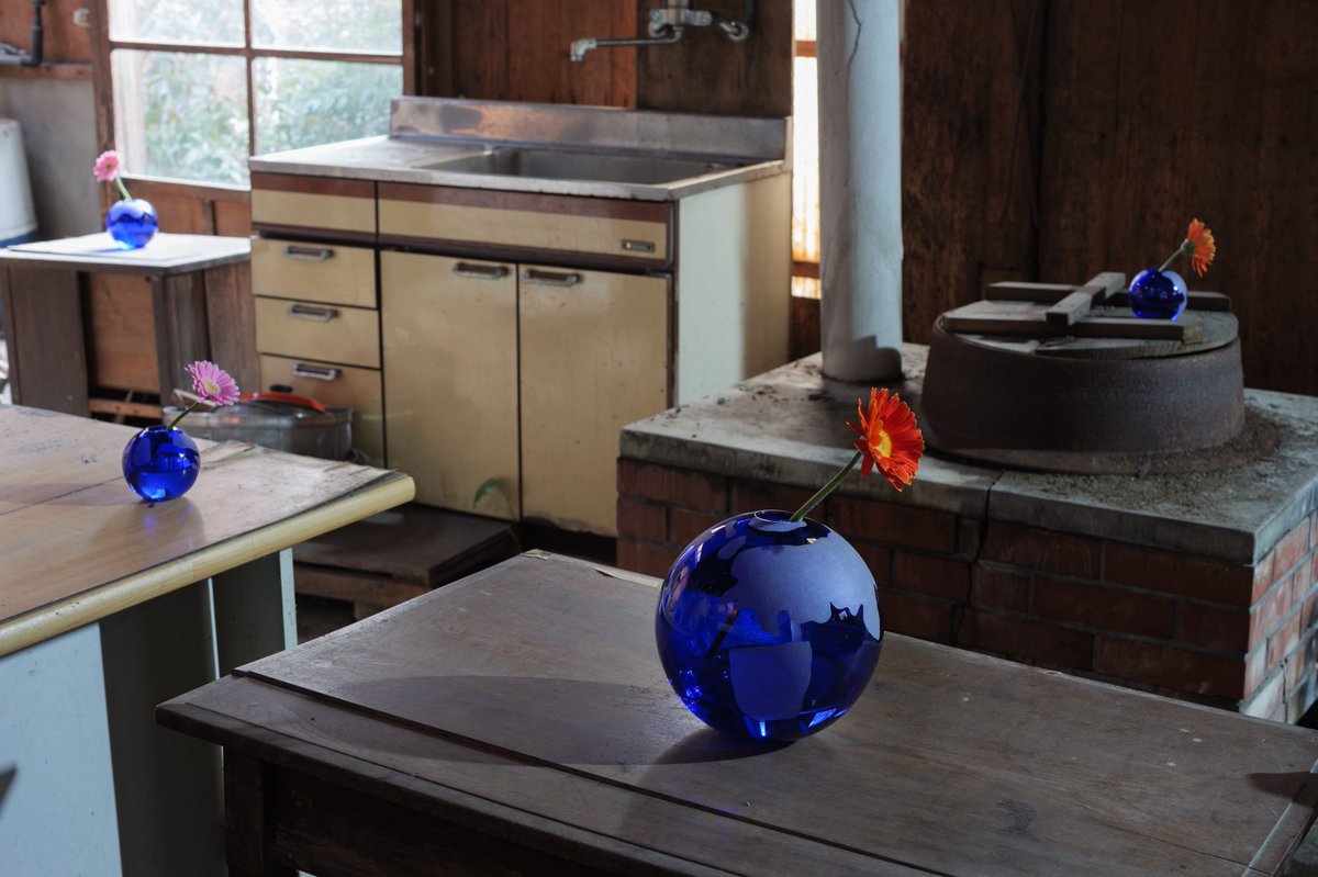 台所に置かれたオレンジの花を挿した青い地球型花瓶