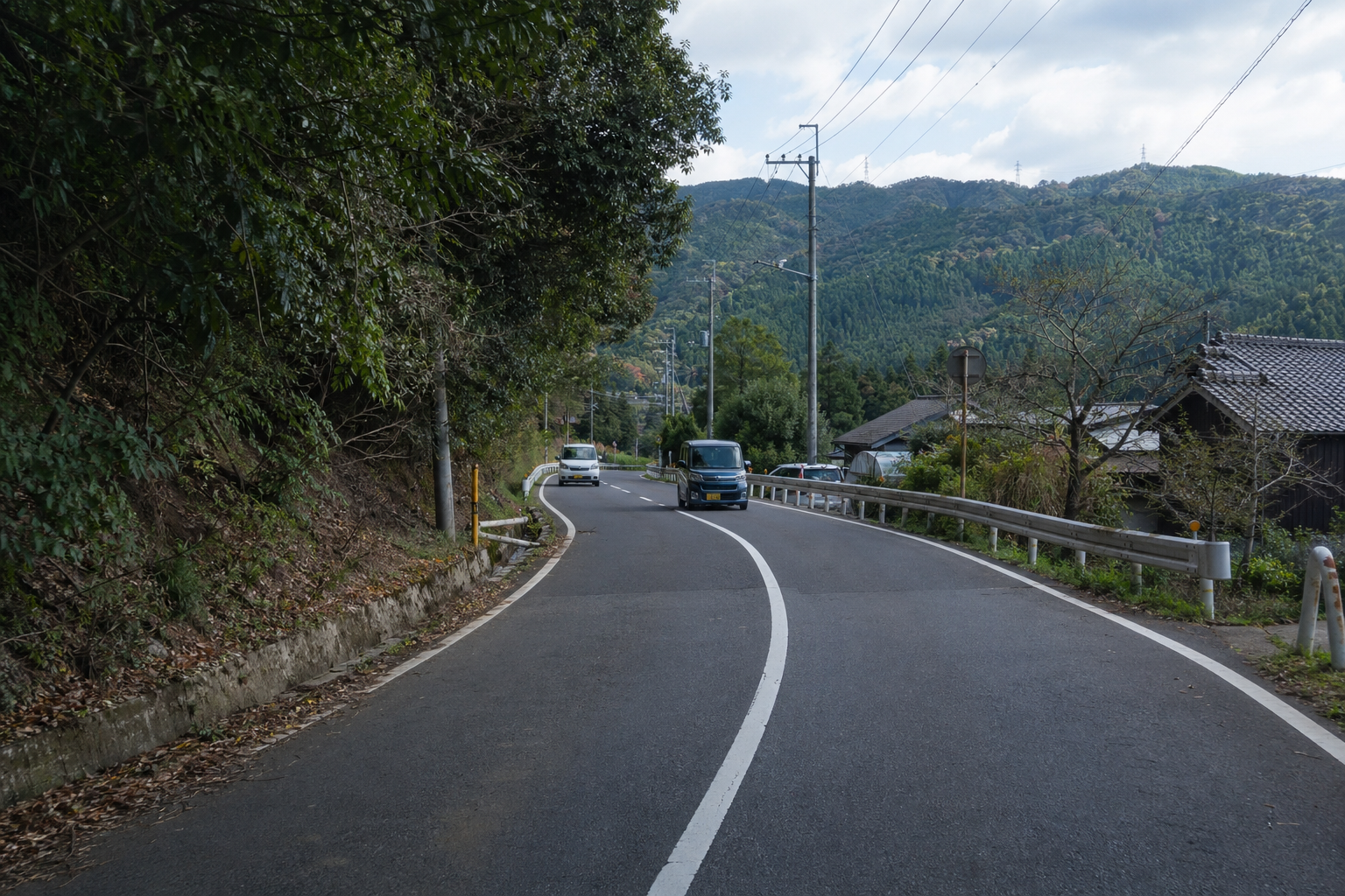 片側1車線の地方の舗装道路のイメージ。追い越しの可否判断を想起させるビジュアル。※事件現場の写真ではない。