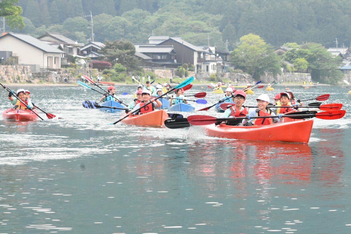 高島市の小学生が琵琶湖でカヤック体験を行う様子（京都新聞掲載写真）