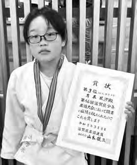 第46回滋賀県少年柔道大会での入賞を記念した万木凪沙さん。柔道着姿で賞状を手に持つ広報誌掲載写真。